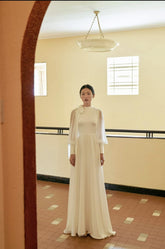 Elegant floor-length silk dress with sheer sleeves and high neck bow detail